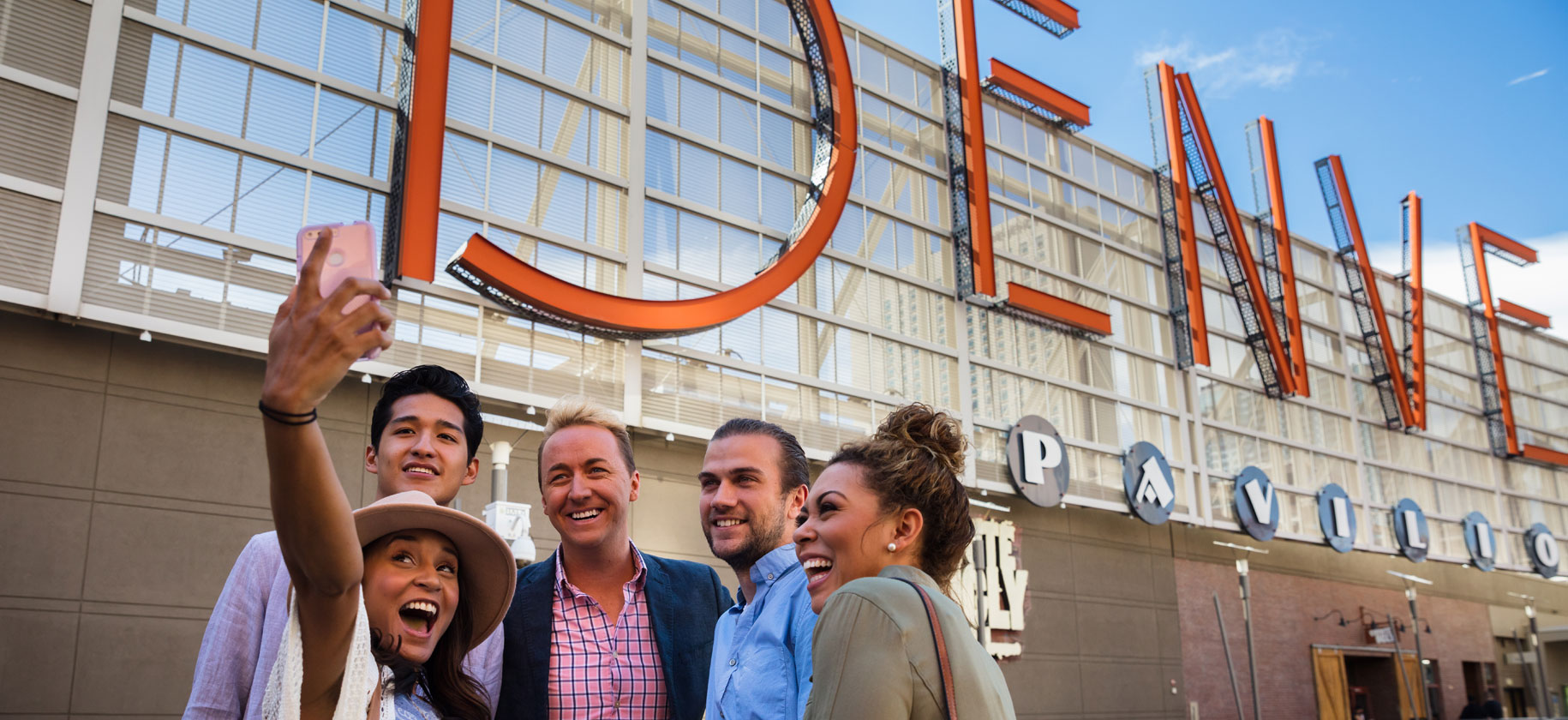 image of people taking a selfie in front of the Denver Pavilions sign
